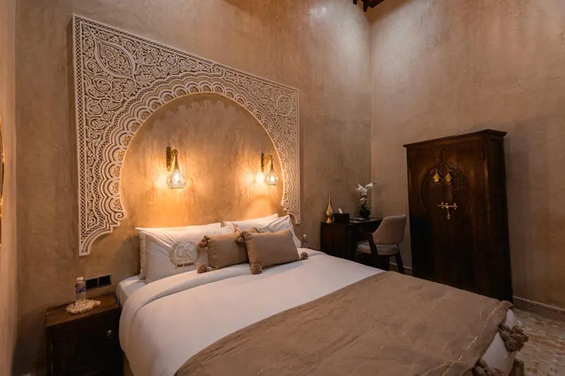 Chambre Taupe, le lit et ses coussins à pompons