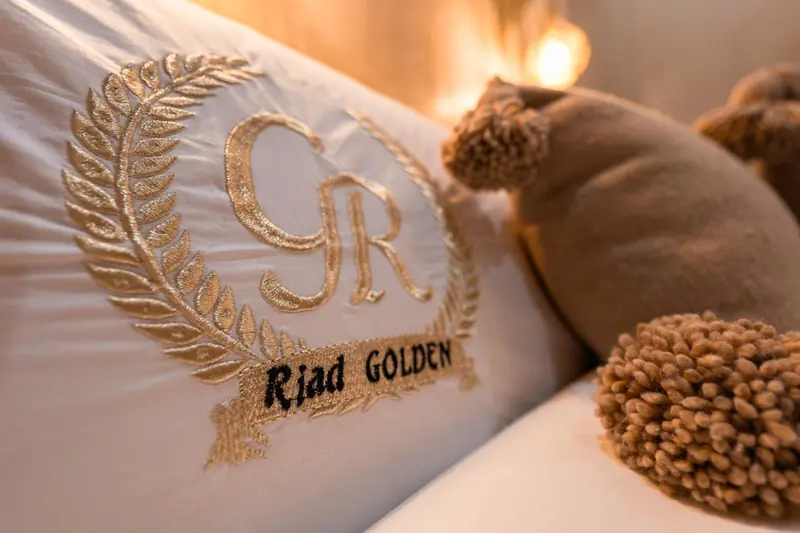 Le blason de la maison brodé sur un coussin